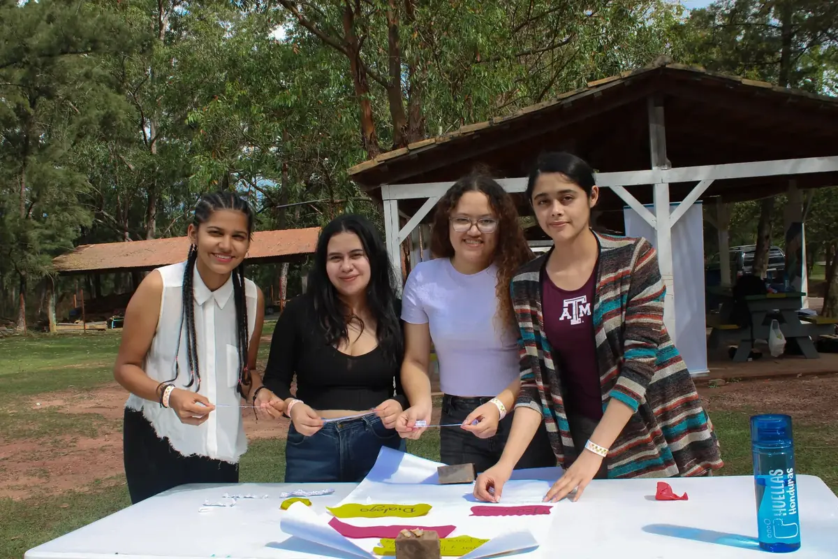 Jóvenes de Huellas Honduras trabajando juntas en una actividad comunitaria